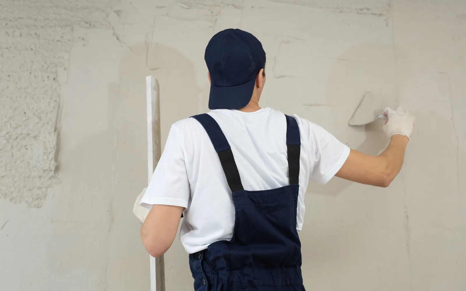 Plasterer smoothing an interior wall with a trowel